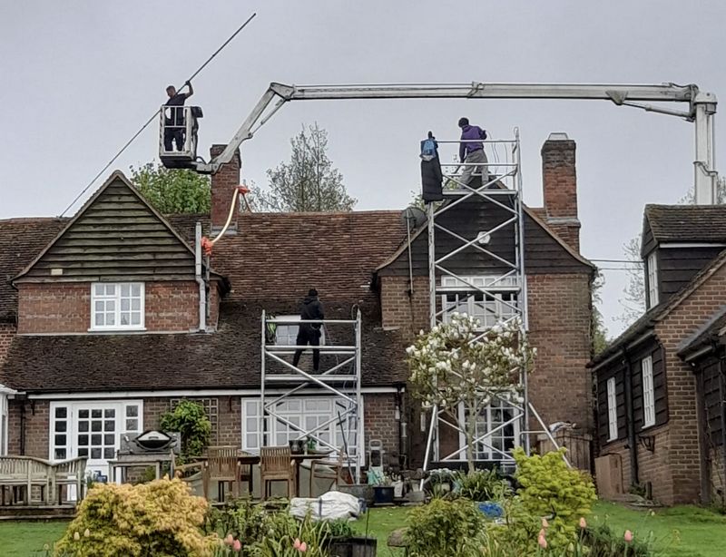 The Roof Moss Cleaners using cherry picker and scaffolding to clean roof safely and professionally in Higham Ferrers, Northamptonshire